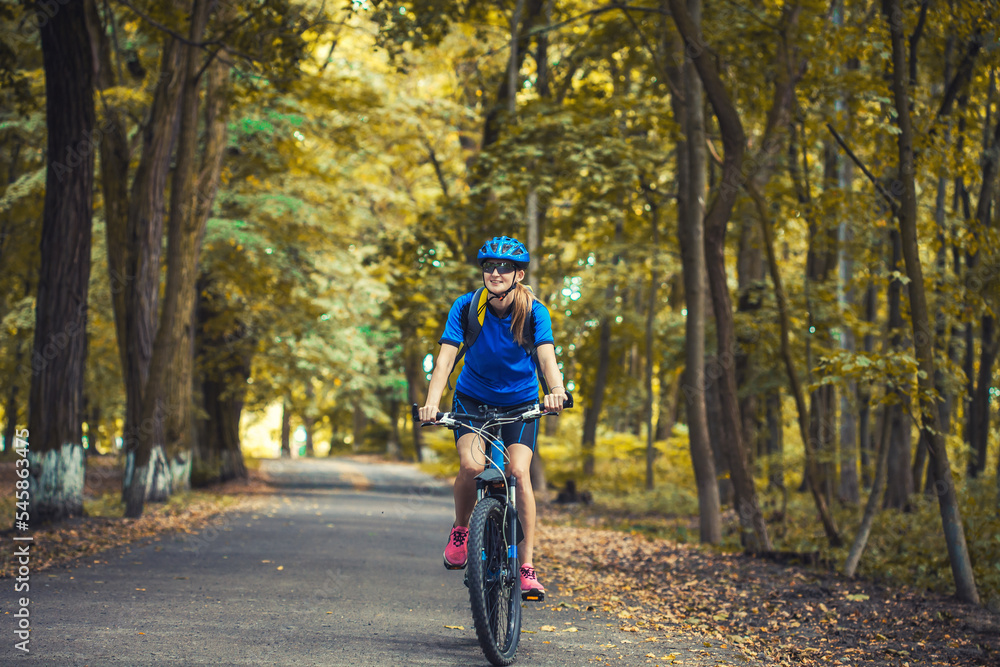 Fototapeta premium woman cyclist rides mountain bike forest trails.