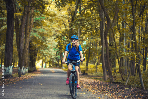 woman cyclist rides mountain bike forest trails.