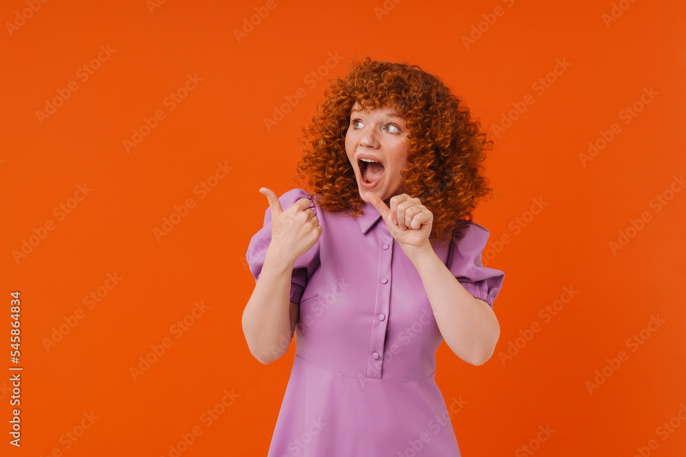 White shocked woman with ginger hair pointing fingers aside White shocked woman with ginger hair pointing fingers aside