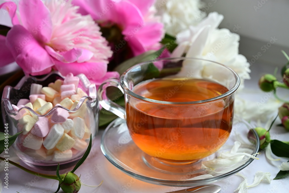 Bouquet of white piones. A tray with a cup of tea and cookies for breakfast. Bouquet of white piones. A tray with a cup of tea and cookies for breakfast.