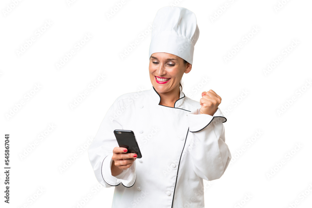 Middle-aged chef woman over isolated background with phone in victory position Middle-aged chef woman over isolated background with phone in victory position