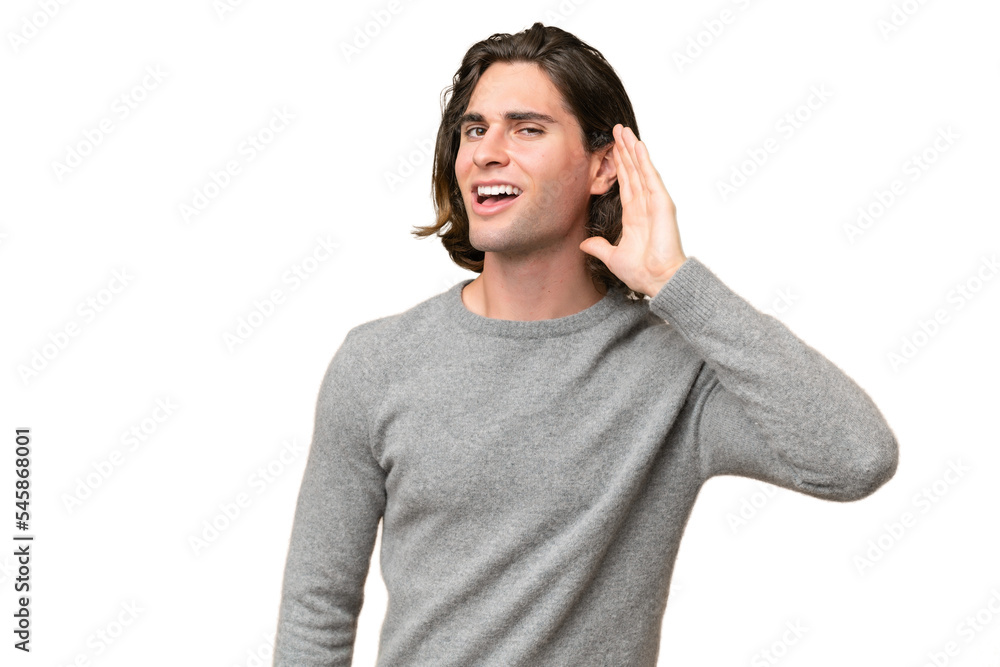 Young caucasian man isolated on green chroma background listening to something by putting hand on the ear Young caucasian man isolated on green chroma background listening to something by putting hand on the ear