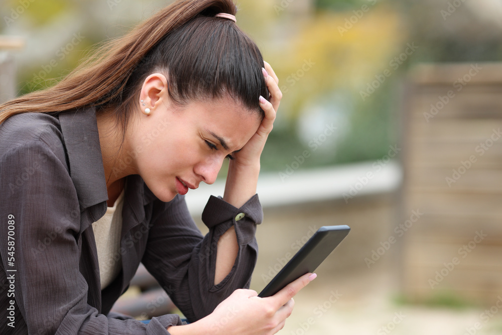 Worried teen complaining checking news on phone Worried teen complaining checking news on phone