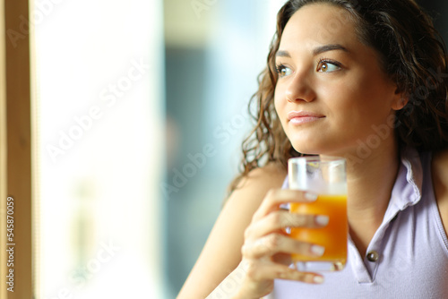 Woman holding orange juice at breakfast