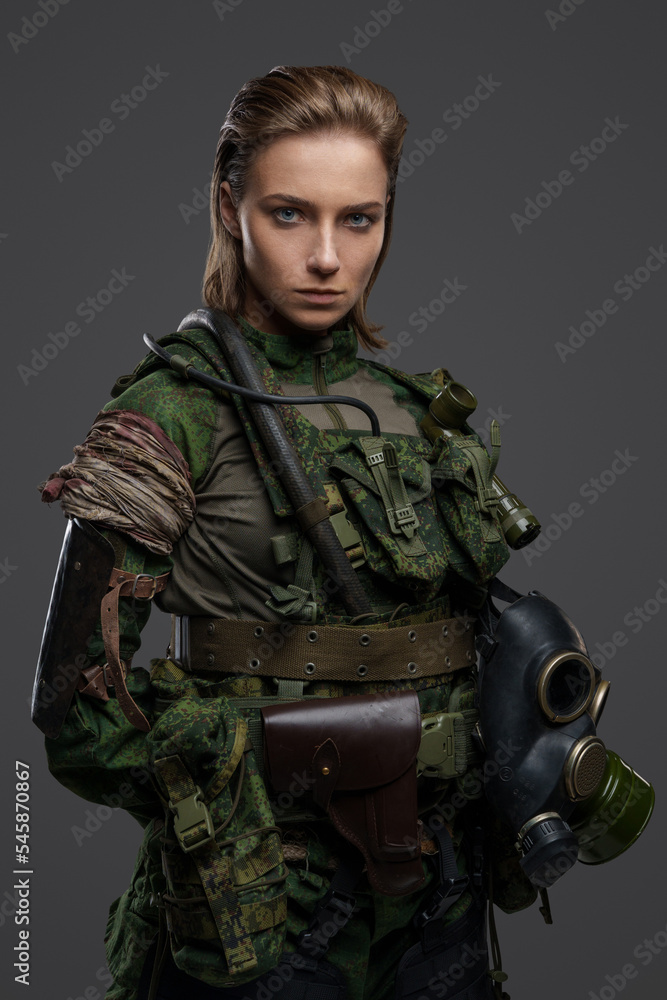 Shot of military woman with brown hairs and gas mask dressed in camouflage costume. Shot of military woman with brown hairs and gas mask dressed in camouflage costume.
