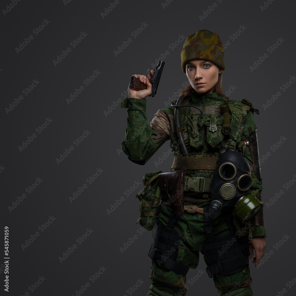 Studio shot of post apocalypse survivor woman with pistol staring at camera. Studio shot of post apocalypse survivor woman with pistol staring at camera.