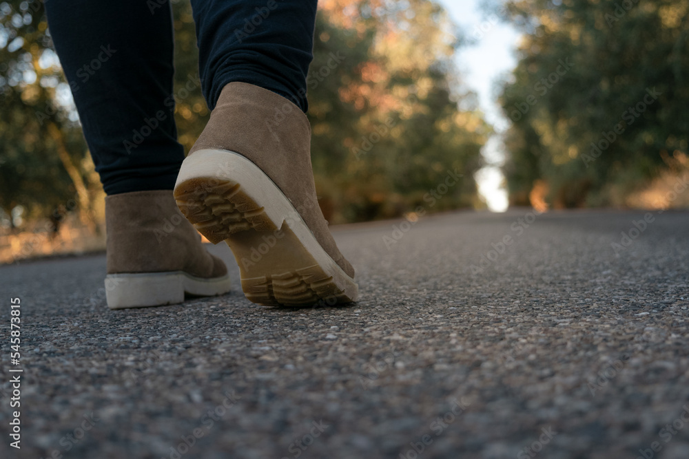 walking with a work boot on the asphalt of a mountain road at sunrise