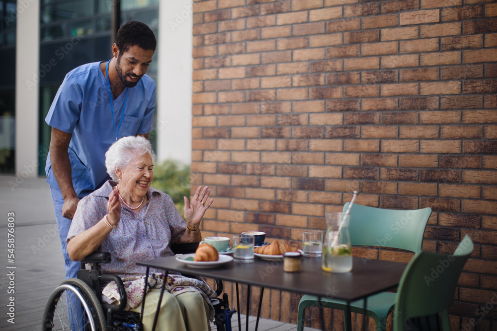 Caregiver having breakfast with his client at cafe. Caregiver having breakfast with his client at cafe.