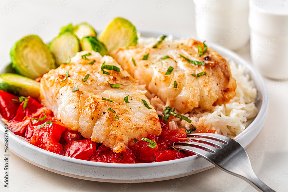 Baked cod fish, with tomato, brussel sprouts and boiled rice. Balanced food concept. Close-up. Baked cod fish, with tomato, brussel sprouts and boiled rice. Balanced food concept. Close-up.