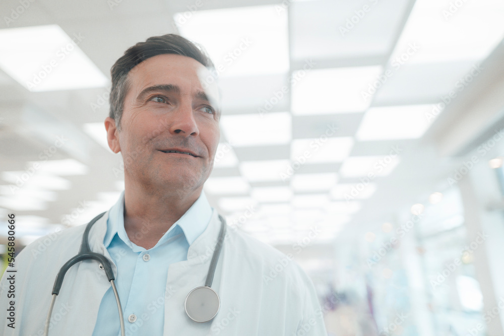 Smiling mature doctor with stethoscope seen through glass Smiling mature doctor with stethoscope seen through glass