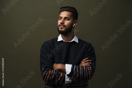 Portrait of man with folded hands with wireless earphones isolated