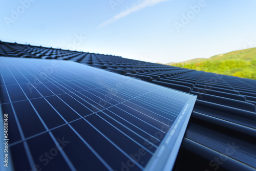 Close-up of solar photovoltaic panels on roof  alternative energy  saving resources and sustainable lifestyle concept.