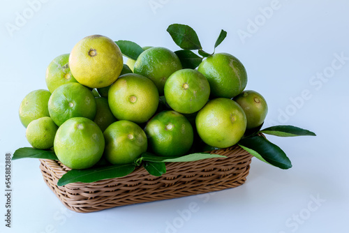 Green lemon in rattan basket for sell at market and supermarket.
