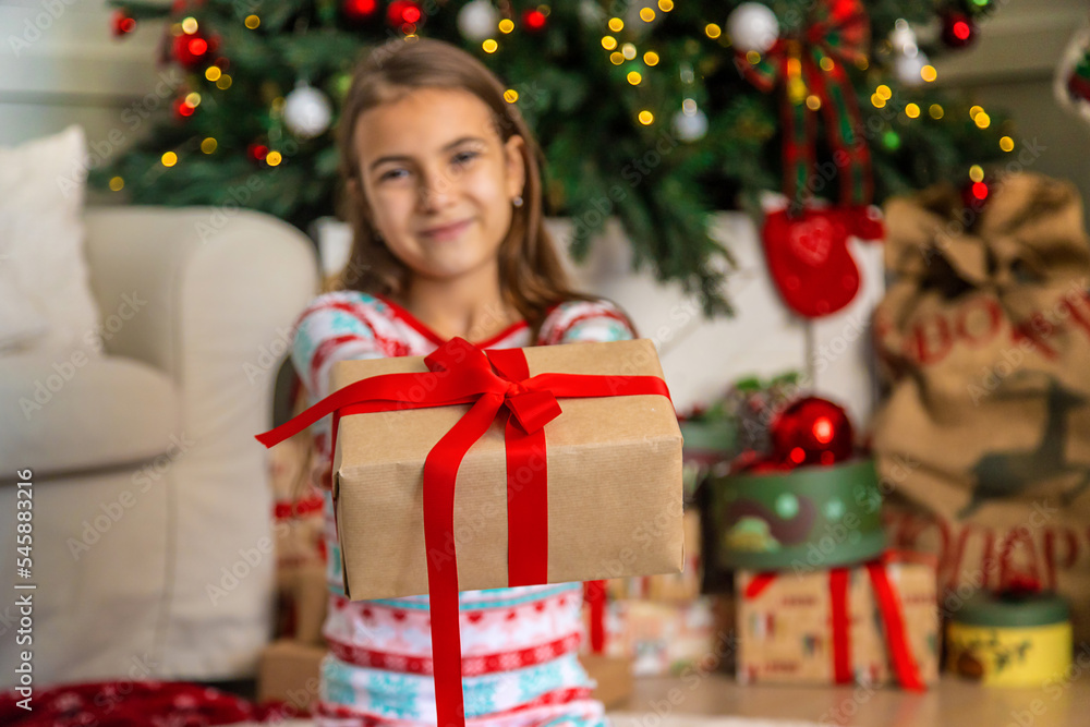 Children near the Christmas tree with a gift. Selective focus. Children near the Christmas tree with a gift. Selective focus.