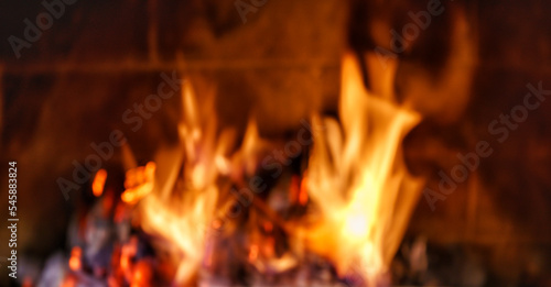 Fire in cozy fireplace, in a country house, winter or autumn holidays,defocused.