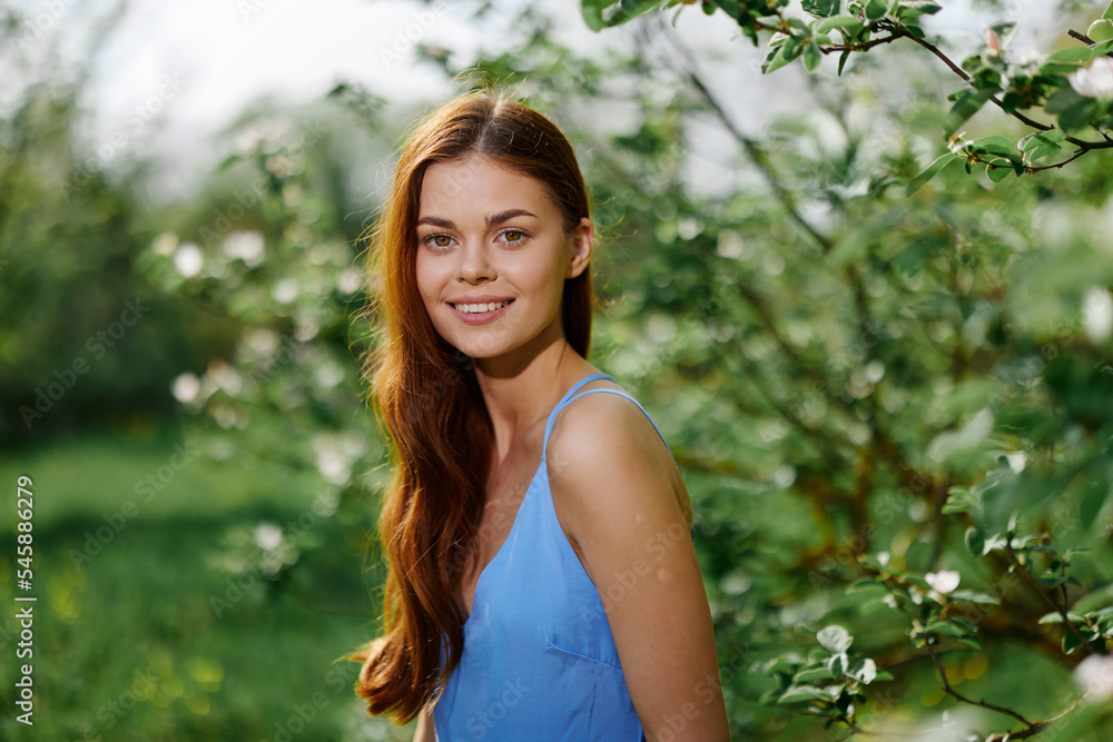 Woman smile with teeth happiness in nature in the summer near a green tree in the garden of the park, the concept of women's health and beauty with nature sunset Woman smile with teeth happiness in nature in the summer near a green tree in the garden of the park, the concept of women's health and beauty with nature sunset