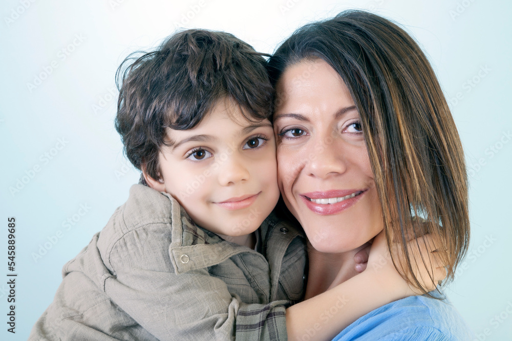 Mother and Her Son are Posing Against Blue Background Mother and Her Son are Posing Against Blue Background