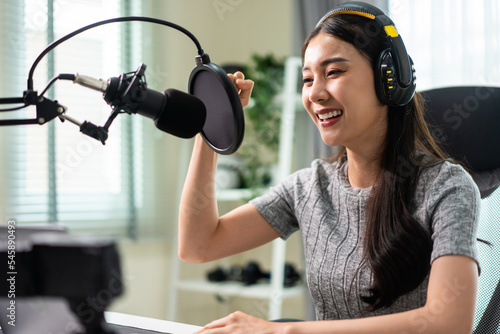 Photography Asian attractive audio DJ woman speaks into microphone to broadcasting