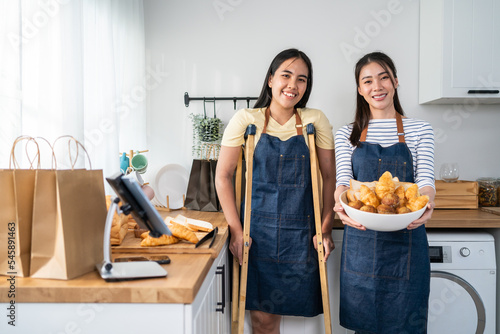 Obraz na płótnie Portrait of Asian female amputee leg stand in kitchen with her friend