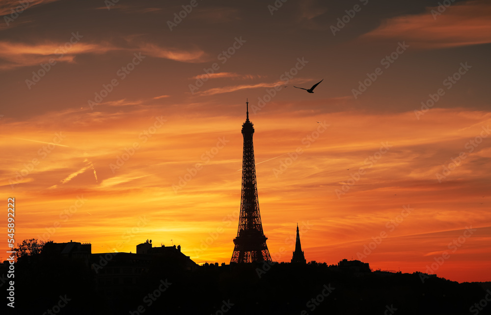 Amazing autumn sunset in Paris. Landscape with silhouette of Eiffel Tower against an orange sky background. Travel to France.
