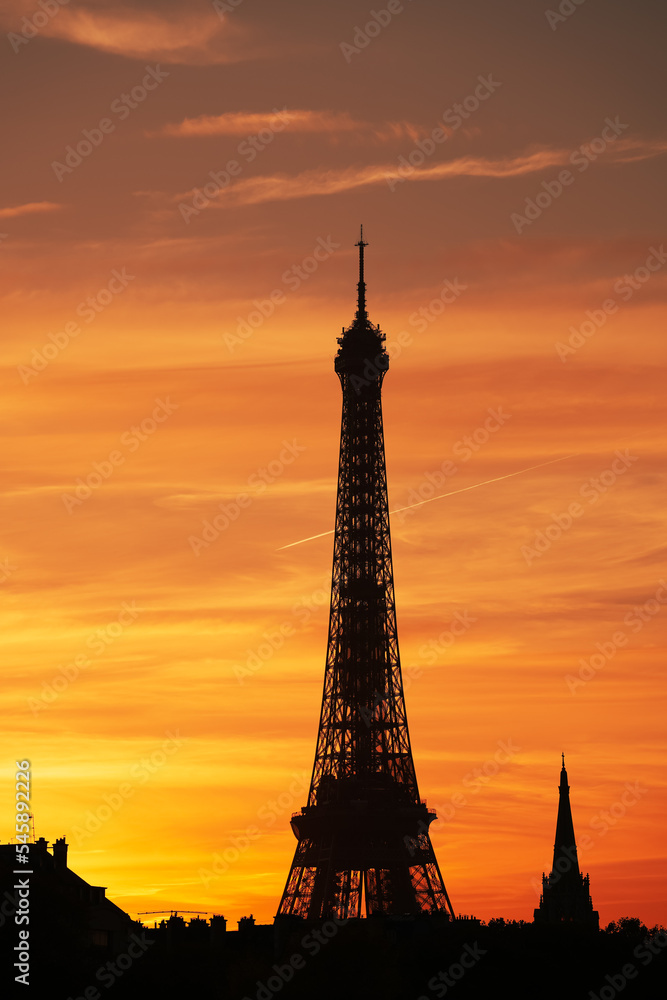 Amazing autumn sunset in Paris. Landscape with silhouette of Eiffel Tower against an orange sky background. Travel to France.