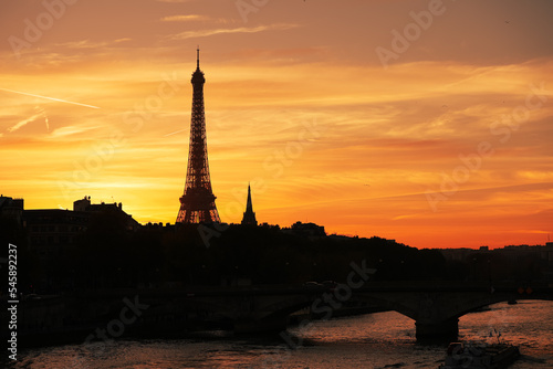 Amazing autumn sunset in Paris. Landscape with silhouette of Eiffel Tower against an orange sky background. Travel to France.