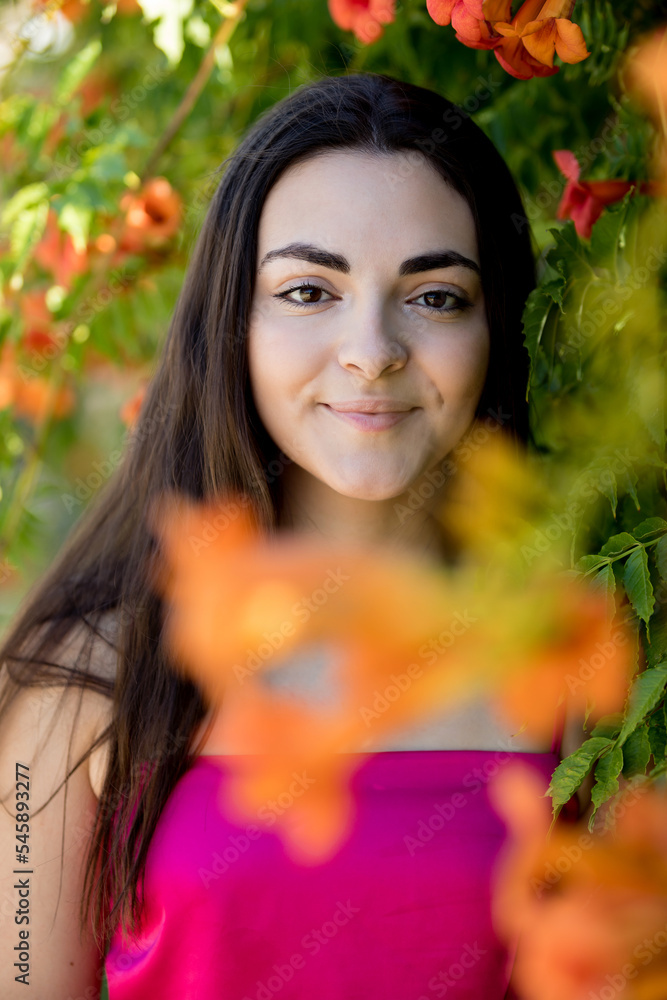 Portrait of a happy lovely and beautiful Spanish young woman in a park.