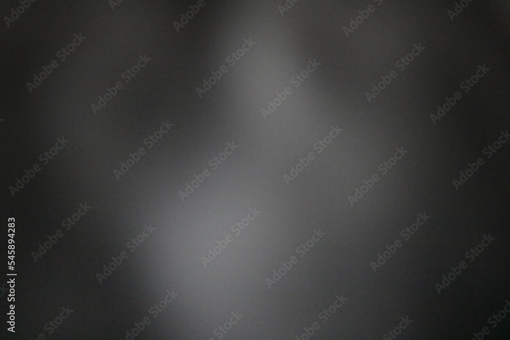 Blurred soft grey coloured mottled background with space for copy