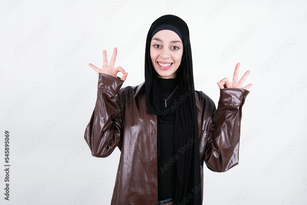 Glad MODEL shows ok sign with both hands as expresses approval, has cheerful expression, being optimistic. Glad MODEL shows ok sign with both hands as expresses approval, has cheerful expression, being optimistic.