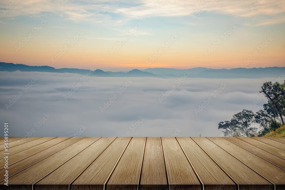 Wooden table and mist mountains landscape in morning sunrise orange color sky