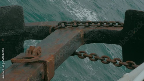 Anchor hanging over the sea close-up