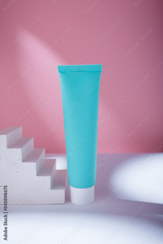 Turquoise tube of cream or tooth paste mockup template with blank label, no brand. Care cosmetics with concrete decor on pink backdrop Turquoise tube of cream or tooth paste mockup template with blank label, no brand. Care cosmetics with concrete decor on pink backdrop