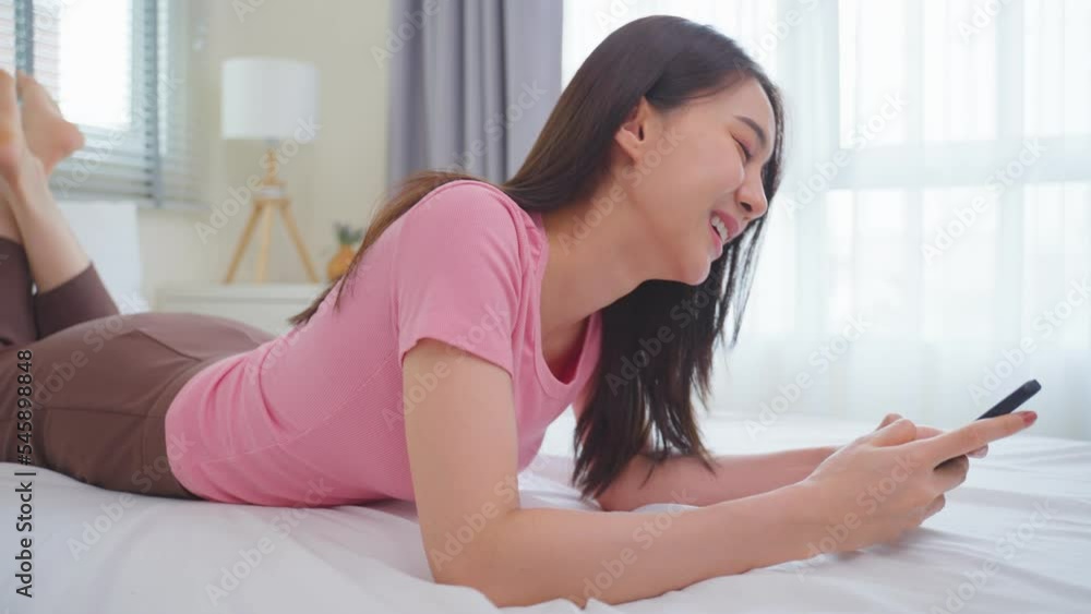 Asian attractive woman use mobile phone chat on bed at home in morning Asian attractive woman use mobile phone chat on bed at home in morning
