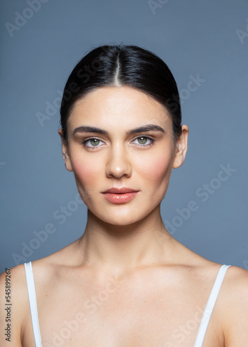 Beauty Woman face Portrait. Beautiful Spa model Girl with Perfect Fresh Clean Skin. Brunette female looking at camera and smiling.