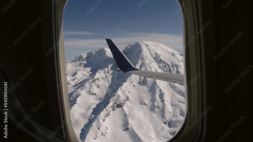 Airplane commercial jet passenger view out of a coach window of Mt. Rainier snow glaciers near seattle washington usa Airplane commercial jet passenger view out of a coach window of Mt. Rainier snow glaciers near seattle washington usa