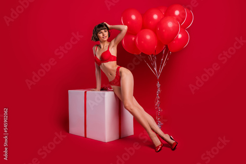 Full length photo of gorgeous lady sit large big package podium lingerie advertisement isolated on red color background © deagreez