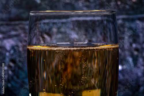 Bubbles in a glass of champagne, on a dark background, macro photography