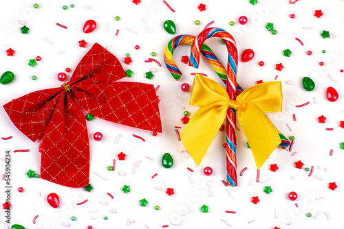 Christmas background of colorful candies, candy canes and bows, on a white background, close-up