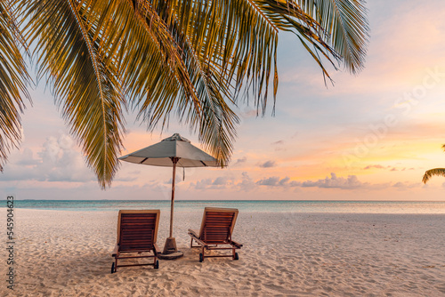 Beautiful panoramic nature. Tropical beach  panorama Exotic sunset summer island landscape love couple chairs umbrella palm leaves shore, coast. Romantic travel destination banner for vacation holiday © icemanphotos