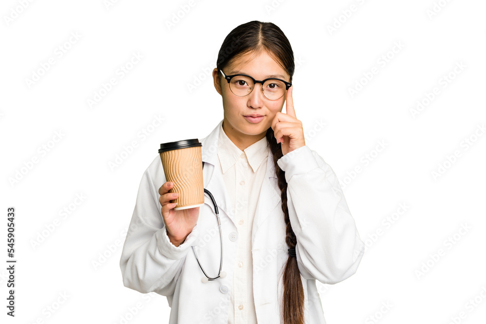 Young doctor asian woman holding a takeaway coffee isolated pointing temple with finger, thinking, focused on a task. Young doctor asian woman holding a takeaway coffee isolated pointing temple with finger, thinking, focused on a task.