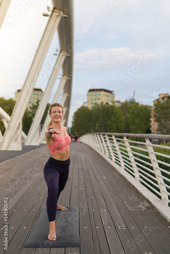 front view of Girl realizing yoga in the middle of the city, warrior pose