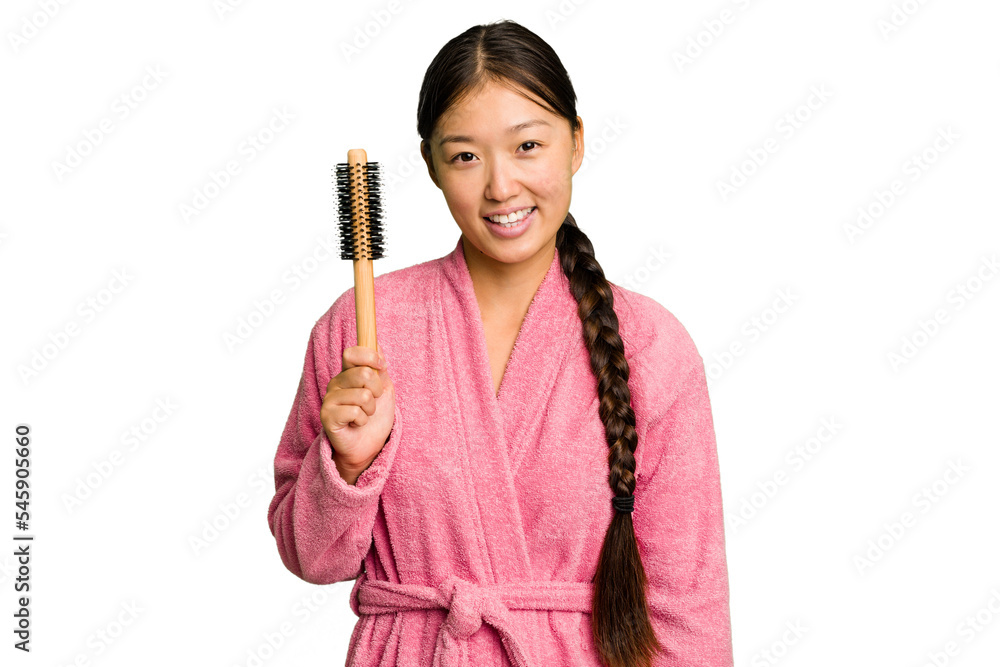Young asian woman holding an hair comb isolated happy, smiling and cheerful. Young asian woman holding an hair comb isolated happy, smiling and cheerful.