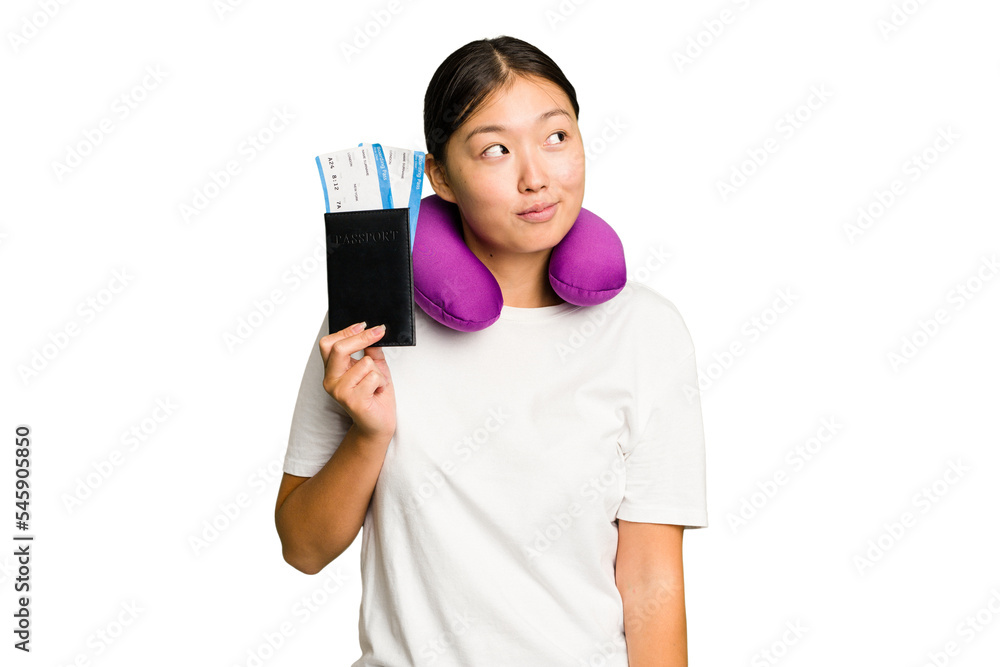 Young asian woman with inflatable travel pillow on her neck holding passport isolated dreaming of achieving goals and purposes Young asian woman with inflatable travel pillow on her neck holding passport isolated dreaming of achieving goals and purposes