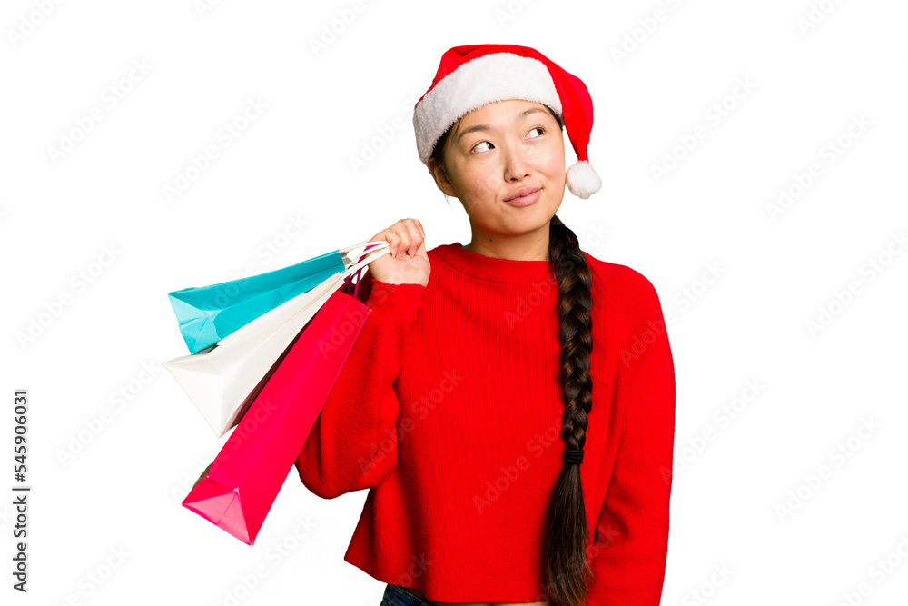 Young asian woman shopping a christmas presents isolated Young asian woman shopping a christmas presents isolated dreaming of achieving goals and purposes Young asian woman shopping a christmas presents isolated Young asian woman shopping a christmas presents isolated dreaming of achieving goals and purposes
