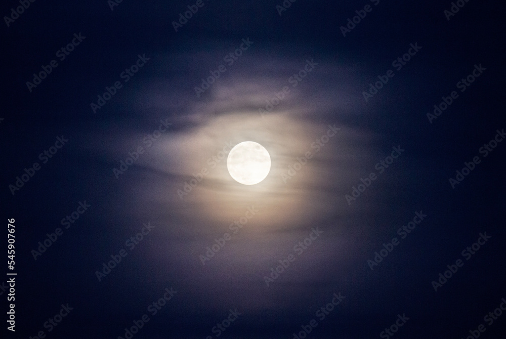 Full moon with clouds at twilight, purple cast Full moon with clouds at twilight, purple cast