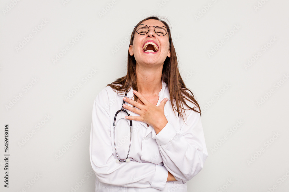 Young doctor woman isolated on white background laughs out loudly keeping hand on chest. Young doctor woman isolated on white background laughs out loudly keeping hand on chest.