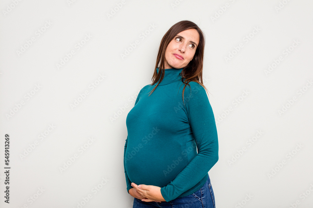 Pregnant caucasian woman isolated on white background looks aside smiling, cheerful and pleasant. Pregnant caucasian woman isolated on white background looks aside smiling, cheerful and pleasant.