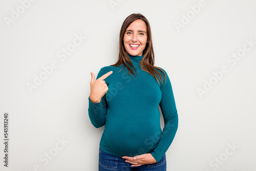 Pregnant caucasian woman isolated on white background person pointing by hand to a shirt copy space, proud and confident