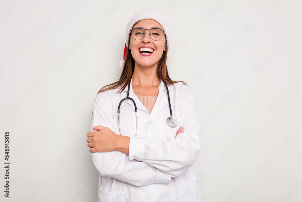 Young caucasian doctor woman wearing a santa hat isolated on white background Young caucasian doctor woman wearing a santa hat isolated on white background