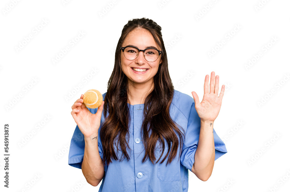 Young caucasian physiotherapist woman holding a tennis ball isolated isolated on green chroma background smiling cheerful showing number five with fingers. Young caucasian physiotherapist woman holding a tennis ball isolated isolated on green chroma background smiling cheerful showing number five with fingers.